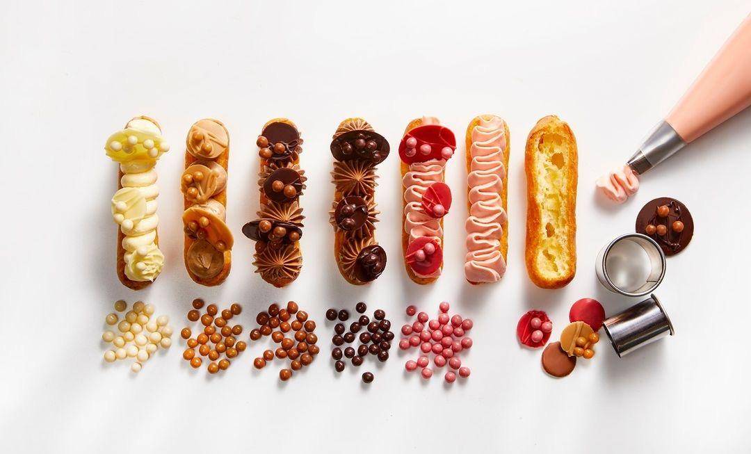 oito eclairs com cores diferentes e decoração dos crispearls visto de cima