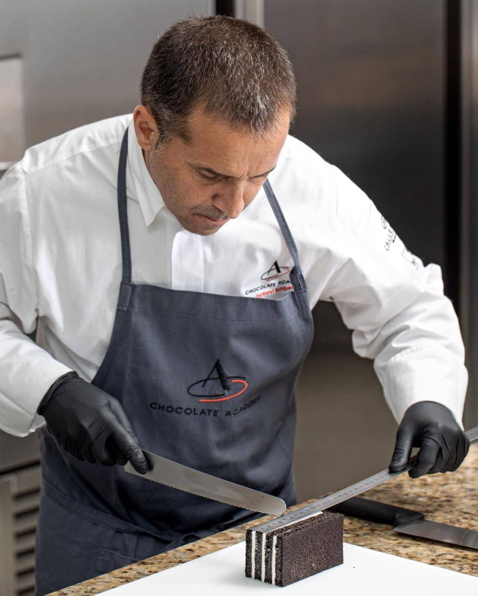 chef cortando receita na cozinha em cima da bancada