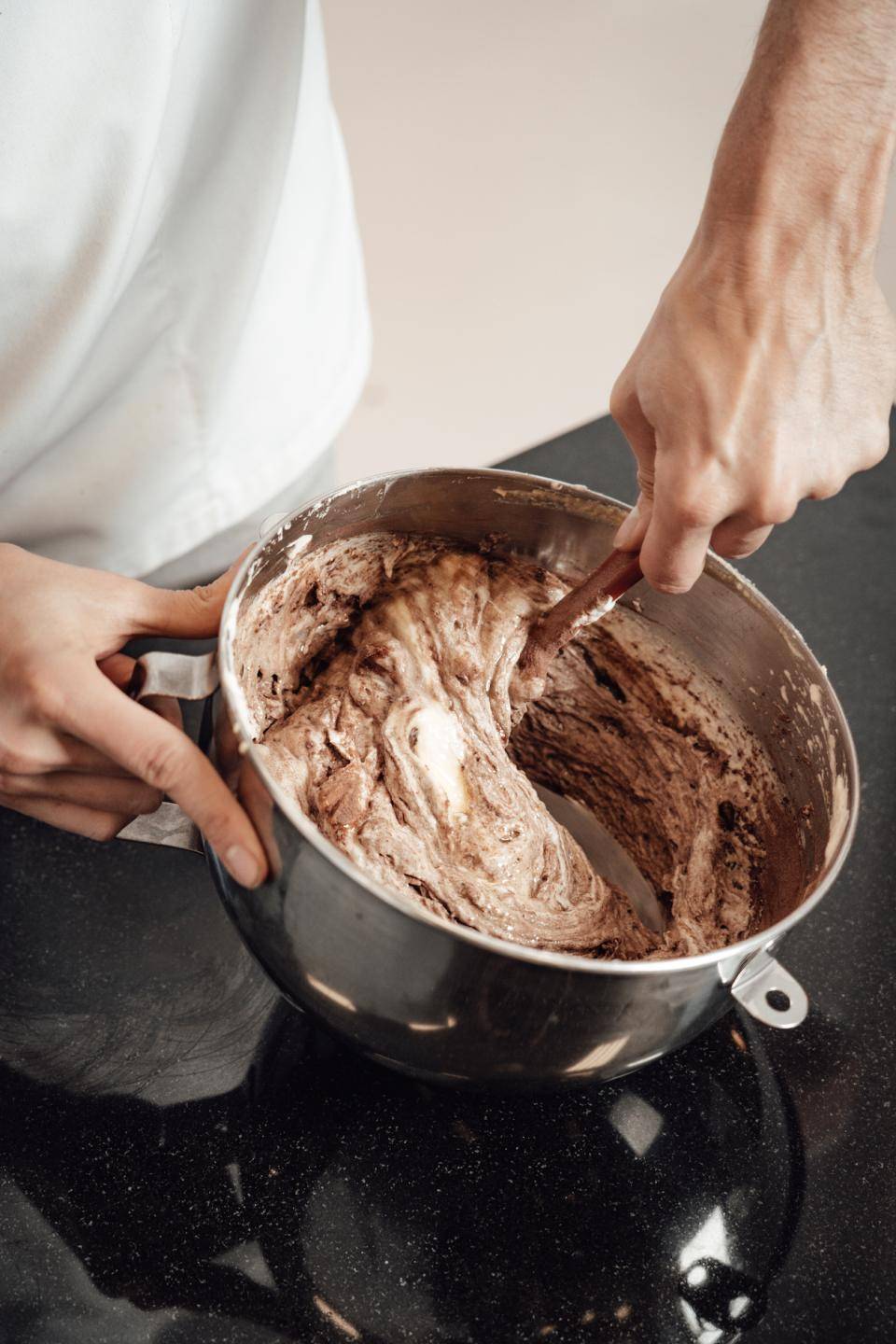 A chef folds egg whites into a sponge batter