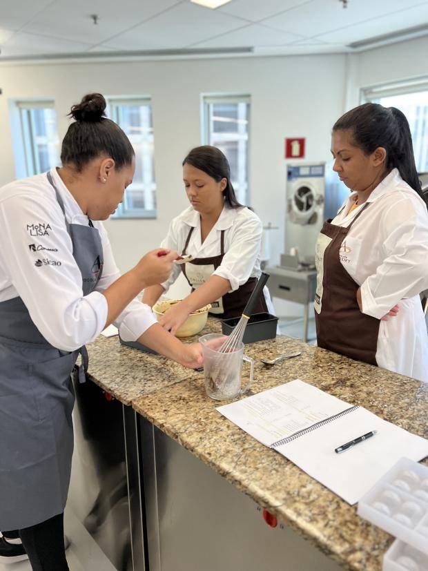 chef dando instrções para pessoas trabalharem com chocolate
