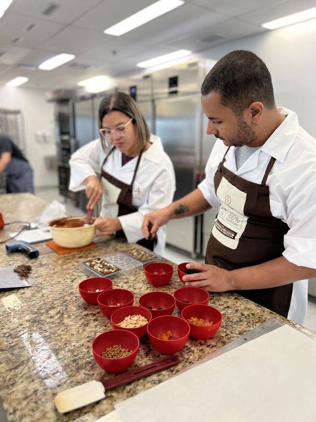 pessoas trabalhando com chocolate em cima do balcão