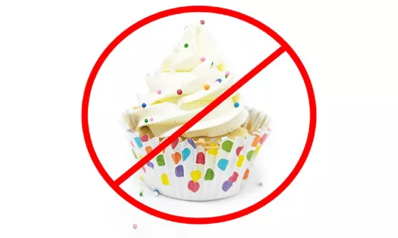 A red circle with a line through it superimposed over a cupcake
