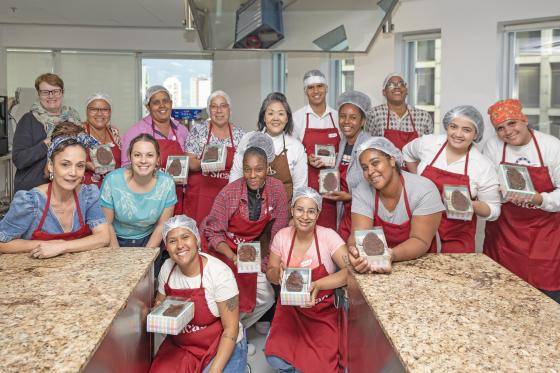 pessoas com o avental da Sicao na Chocolate Academy SP segurando suas criações de Páscoa